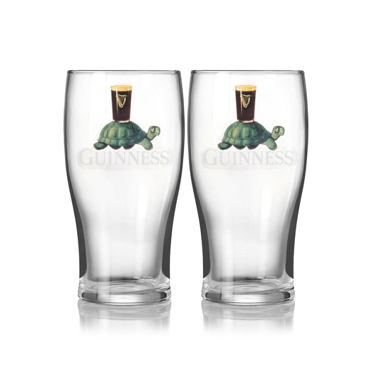 The Guinness Gilroy Tortoise Pint Glass - 2 Pack from Guinness Webstore US features two clear glasses with the iconic Gilroy tortoise carrying a pint and the classic Guinness logo on the front.