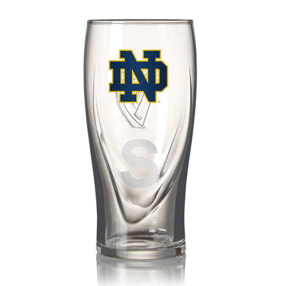 The Guinness Notre Dame 16oz Pint Glass features a clear design with an "ND" logo and large "S," ideal for Notre Dame Football fans. A personalized gift that adds a special touch to every Guinness pint.