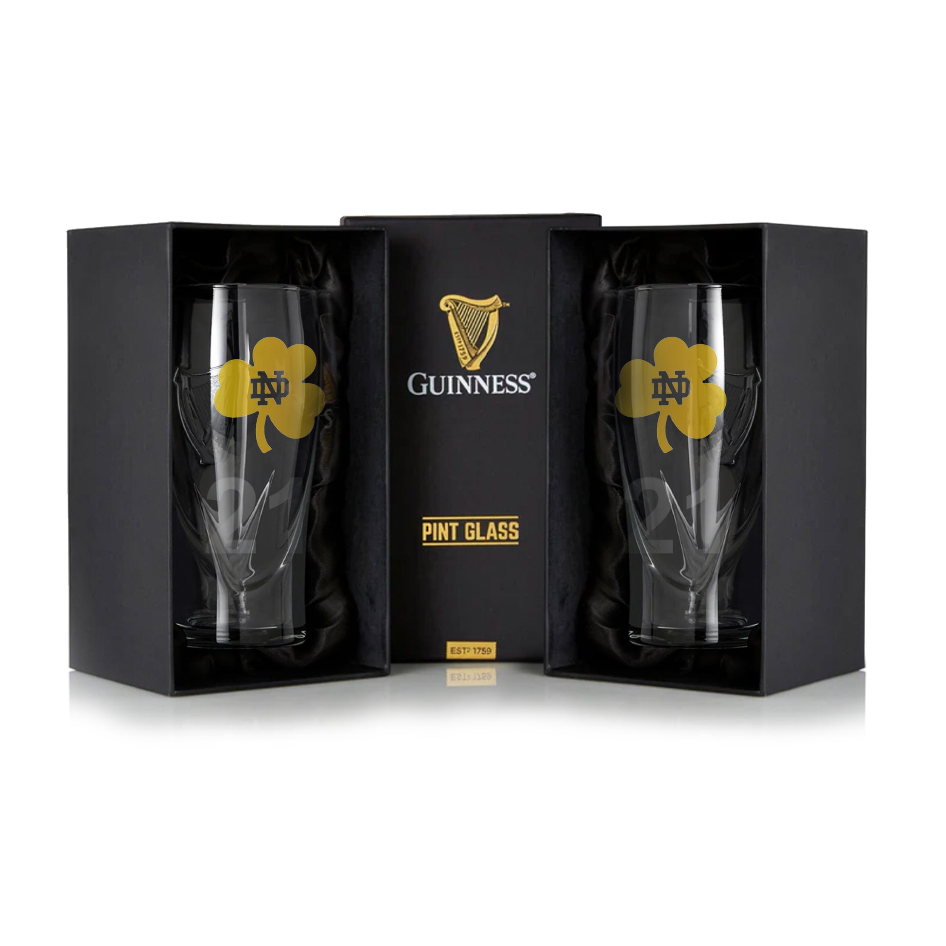 Two 16oz Notre Dame Guinness Shamrock pint glasses come in black packaging with a yellow clover and "ND" logo, set against a white background.