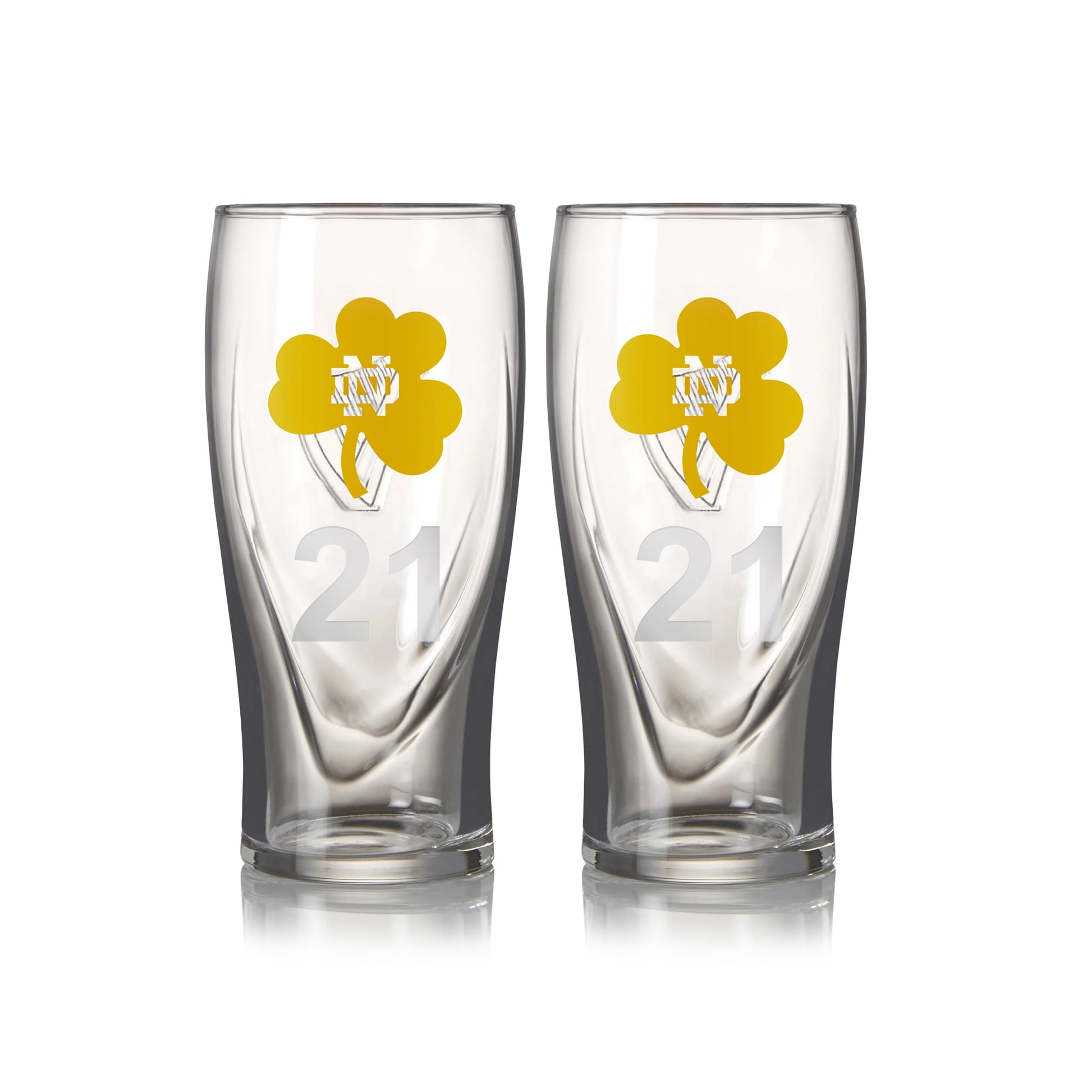 A twin pack of Guinness Notre Dame pint glasses, each 16oz, featuring transparent glass with yellow shamrock designs and the number "21".