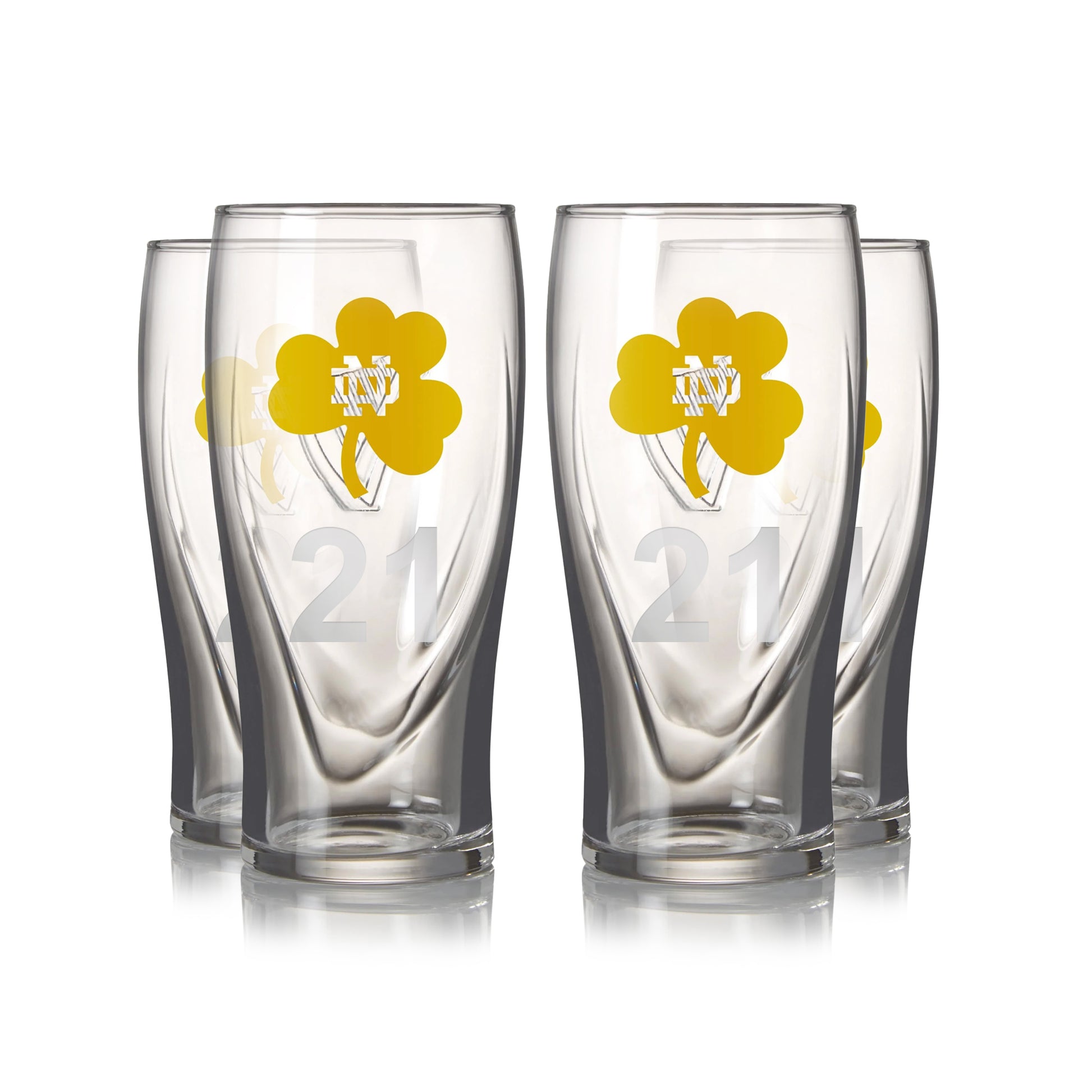 A set of four Guinness 16oz pint glasses features yellow shamrocks and the number 21, arranged in two rows.