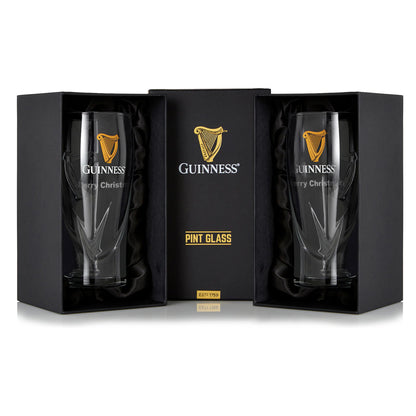 The Guinness Pint Glass Twin Pack includes two glasses in black gift boxes, adorned with a gold harp logo and "Merry Christmas" text—perfect for any beer glass collection.