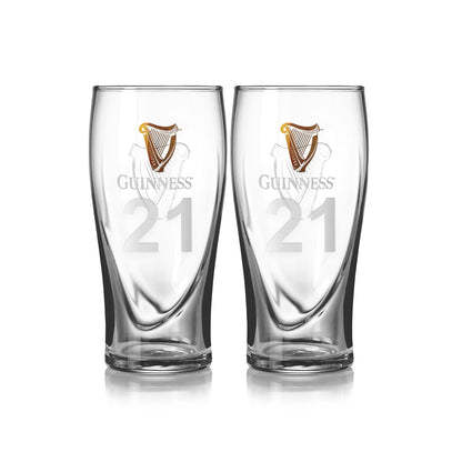 The Guinness Pint Glass Twin Pack includes two clear pint glasses featuring the iconic harp logo and number 21, perfect for enjoying your favorite brew. Both branded beer glasses are side by side on a white background.