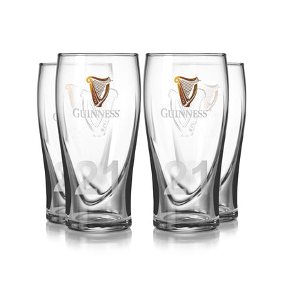 The Guinness Pint Glass 4 Pack includes four clear glasses, each adorned with the iconic Guinness logo and harp emblem. The number "21" is etched near the base of each glass.