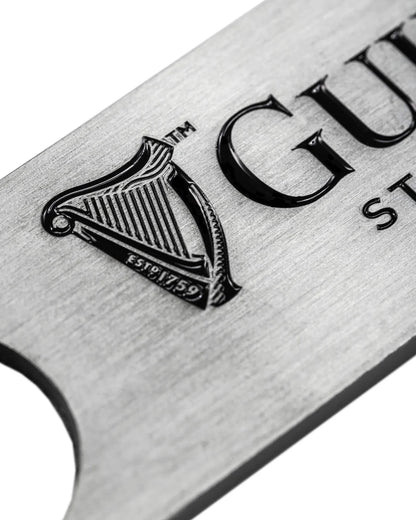 The Guinness Barman Bottle Opener from Guinness Webstore US features the iconic harp logo and "ESTD 1759" engraving—a classic, metallic bar tool ideal for any home bar.