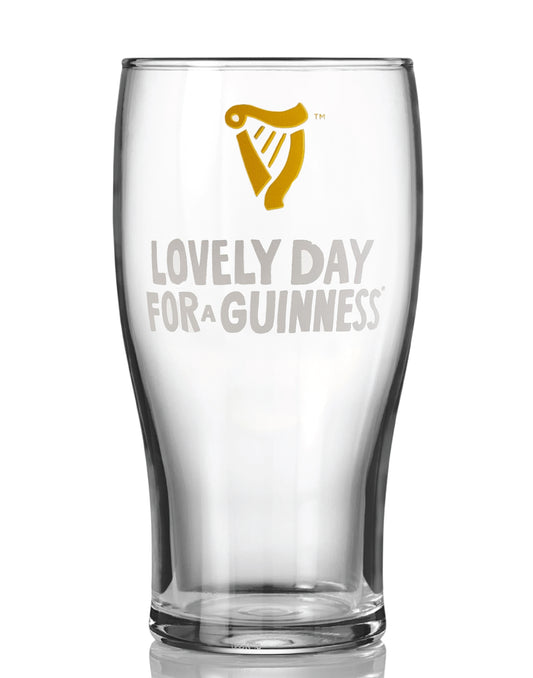 The Guinness Seb Curi Lovely Day Pint Glass from Guinness Webstore US features the iconic golden harp logo and "Lovely Day for a Guinness" on the front—a true Collector’s Edition piece.