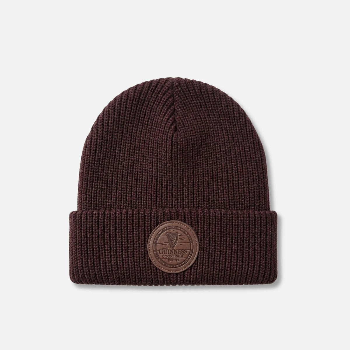 The Guinness Cooperage Brown Knitted Beanie features a dark brown knit, folded brim, and a front leather patch with an embossed Guinness logo.