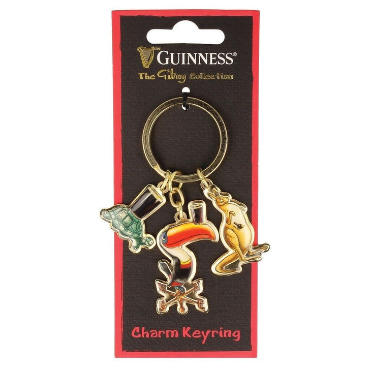 The Guinness US Gilroy Charm Keyring Toucan features metal charms—a tortoise, a toucan with a pint of Guinness, and a kangaroo—attached to branded card backing.