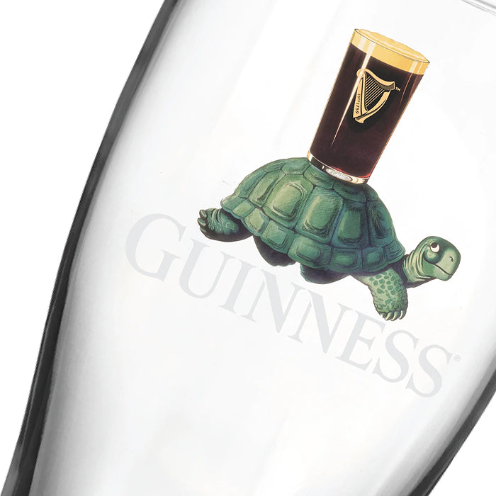 A glass from the Guinness Gilroy Christmas Glass Set, featuring a turtle with a Guinness pint—perfect as a unique Christmas gift from Guinness Webstore US.