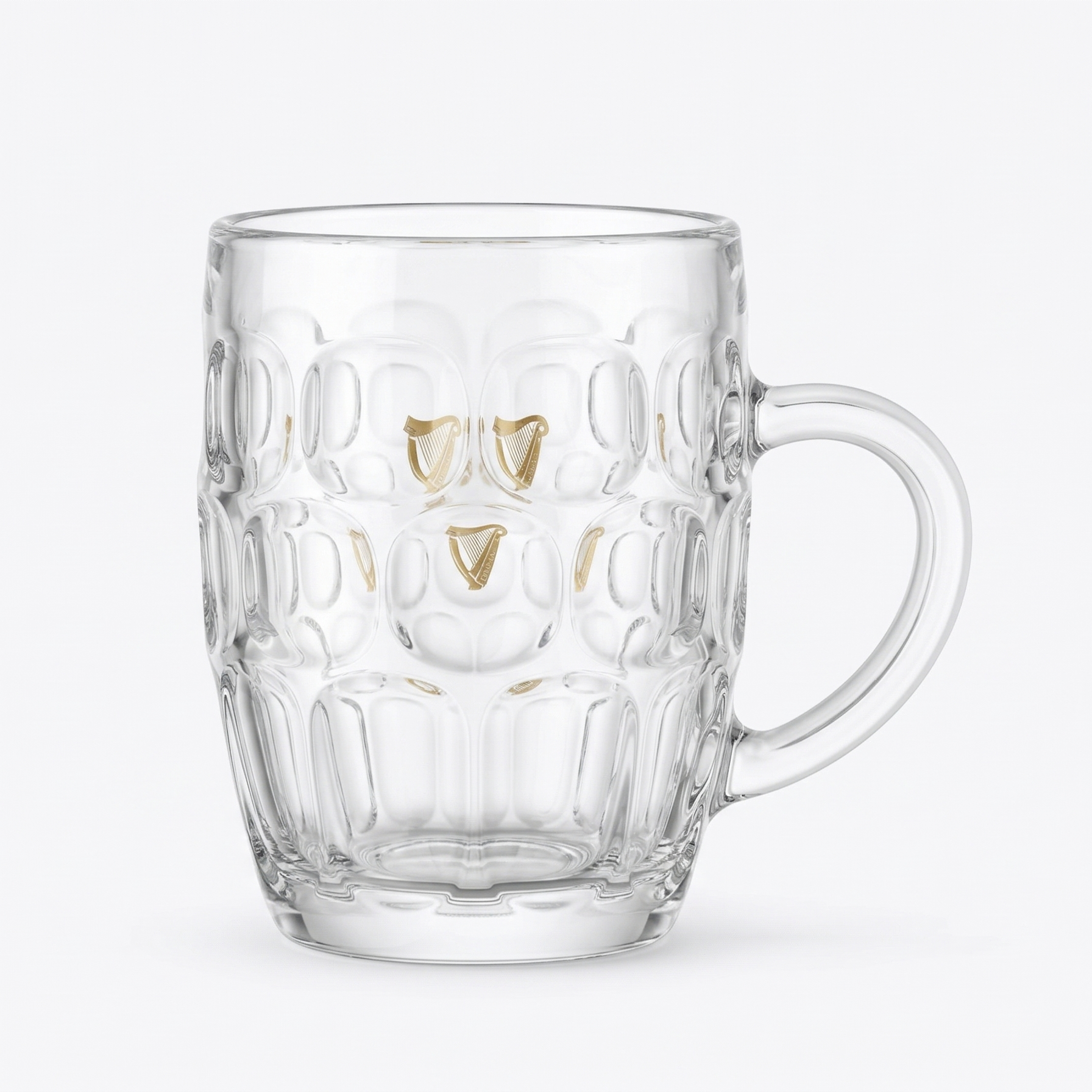 The Guinness Gold Harp Dimple Glass Mug – 20 oz Tankard from Guinness Webstore US features clear glass with a geometric texture, gold accents, and a handle—ideal as an Irish pub glass or for enjoying your favorite Guinness.