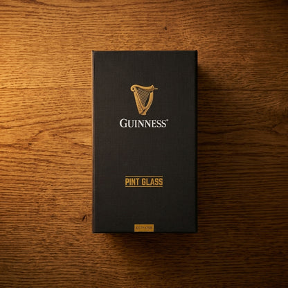 A black box featuring the Guinness harp logo and the words “Guinness Pint Glass” rests on a wooden surface, photographed from above—beautifully showcasing the elegance of the Guinness Pint Glass Luxury Gift Box from Guinness Webstore US.