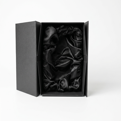 The Guinness Pint Glass Luxury Gift Box from Guinness Webstore US features open sides that showcase an interior lined with glossy black satin, all beautifully presented against a plain white background.