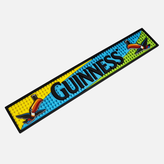 The Guinness Toucan PVC Bar Mat is displayed on a vibrant bar mat for your home bar.