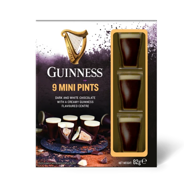 Guinness Luxury Chocolate Mini Pints, a premium treat blending dark and white chocolate cups with a creamy flavored center, showcased beside images of opened chocolates. Net weight: 82g.