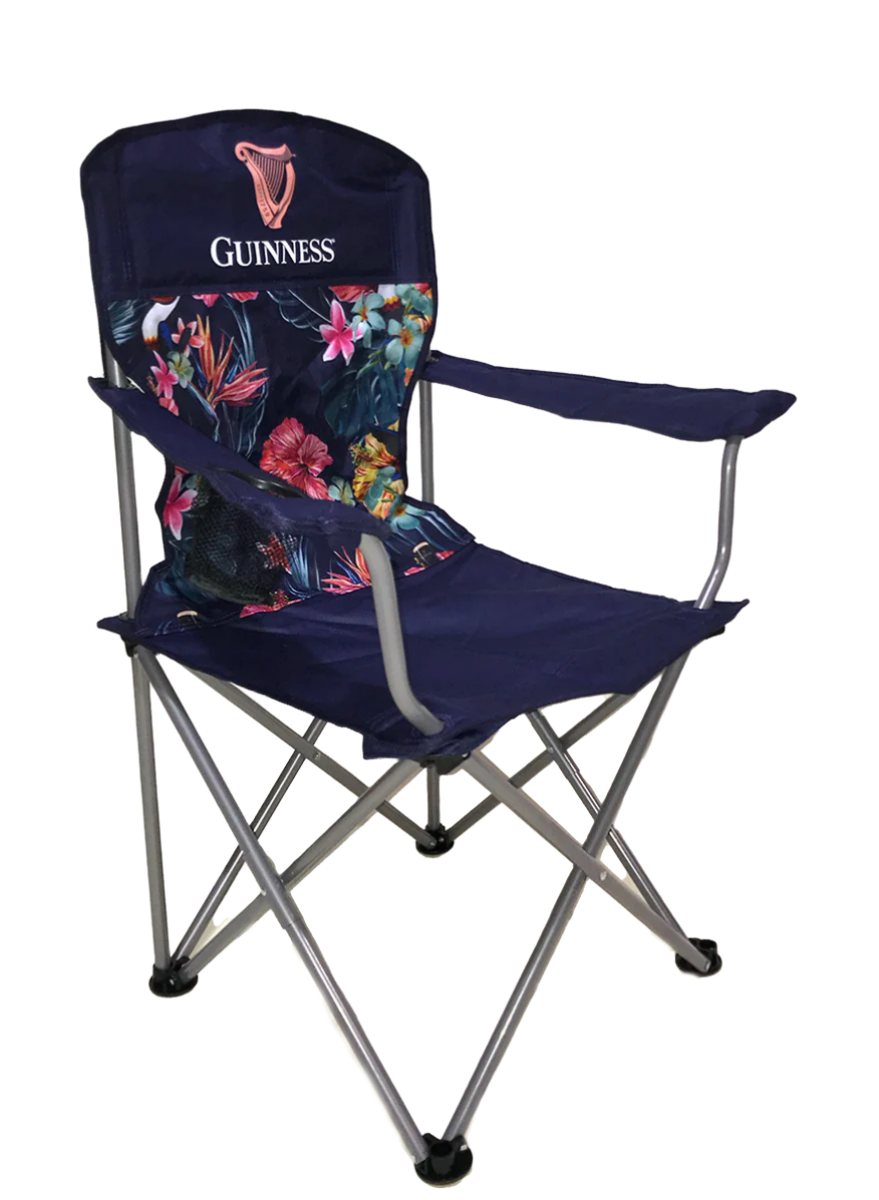 The Guinness Toucan Hawaiian Beach Chair, from the Guinness Webstore US, features a floral backrest design with a Guinness logo, armrests, and collapsible metal legs. It's ideal for pairing with the Guinness Toucan Hawaiian Cooler Bag on your outdoor adventures.