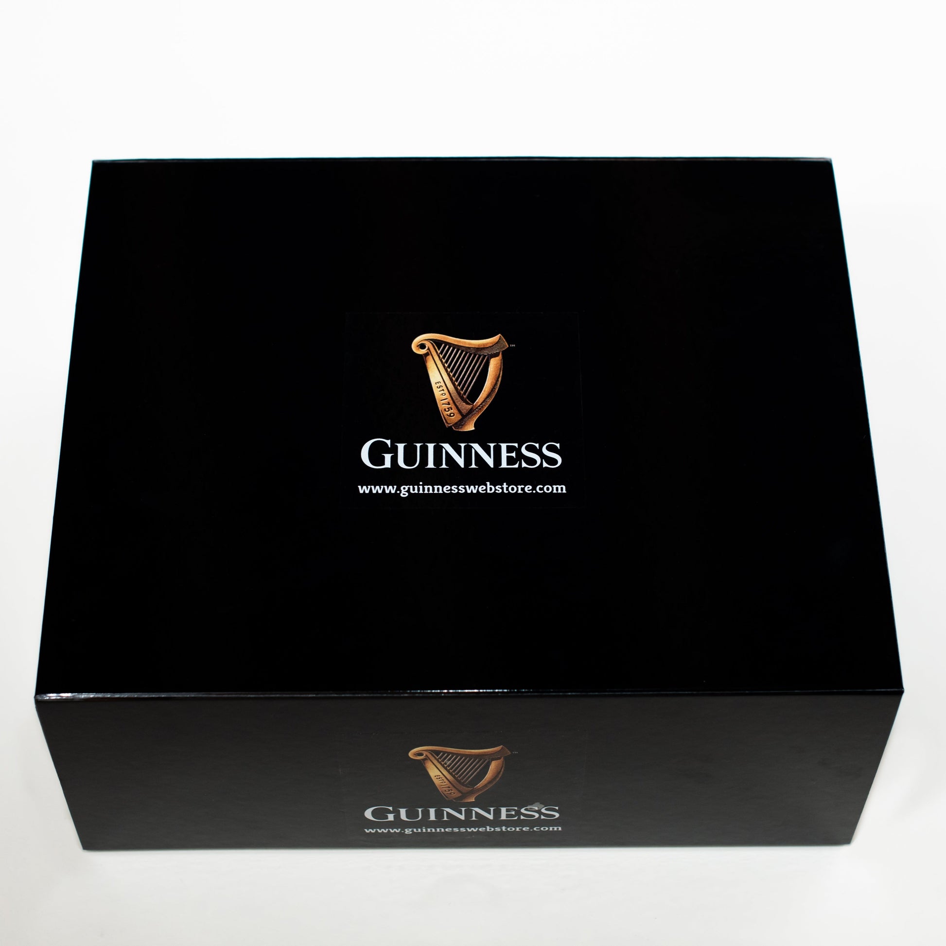 A large, rectangular Guinness Gift Box in black, featuring the iconic Guinness logo and the text "Guinness" along with a website URL on the top and front sides, showcases its high quality as a collector's edition.