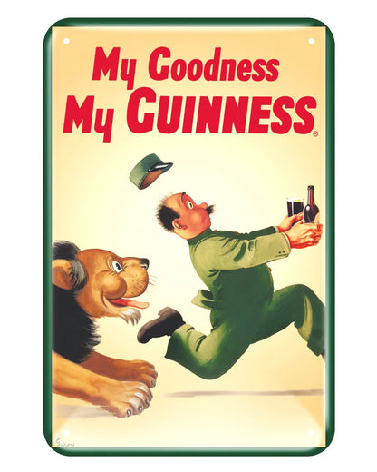 The Guinness Metal Sign - Lion Zoo Keeper from Guinness Webstore US showcases a man in green, the lion zoo keeper, sprinting away from a lion while holding a bottle and glass of Guinness. The prominent text reads, "My Goodness My Guinness!