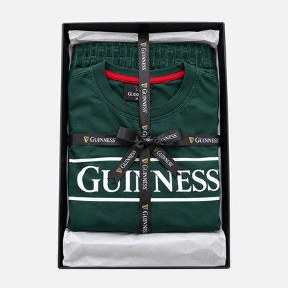 Guinness Unisex 2-Piece Pajama Set – Green featuring a graphic logo shirt and matching pants, folded in a gift box and tied with a branded ribbon.