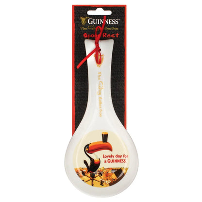 Guinness Gilroy Toucan ceramic spoon rest featuring a toucan balancing a pint glass on its beak with the text “Lovely day for a GUINNESS,” packaged on a branded display card.