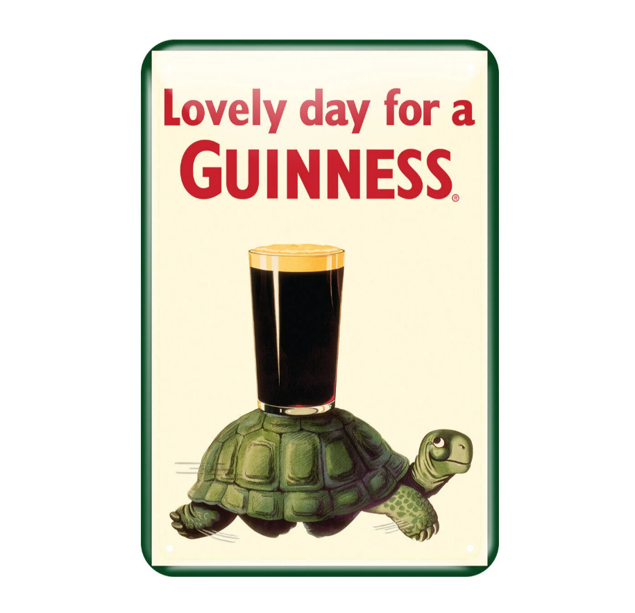 The Guinness Metal Sign - Tortoise from Guinness US features a delightful tortoise carrying a pint of stout on its back, complemented by the classic phrase, "Lovely Day for a Guinness," in celebration of enduring Irish heritage.