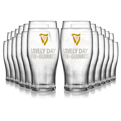 A 24-pack of Guinness Seb Curi Lovely Day Pint Glasses from Guinness Webstore US, featuring the "Lovely Day For A Guinness" design and iconic harp logo in gold and white on the front.