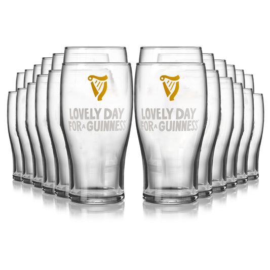 A 24-pack of Guinness Seb Curi Lovely Day Pint Glasses from Guinness Webstore US, featuring the "Lovely Day For A Guinness" design and iconic harp logo in gold and white on the front.