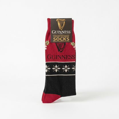 Guinness Harp & Holly Holiday socks in red and black, featuring a harp emblem, holly and snowflake patterns, and a branded product tag at the top.
