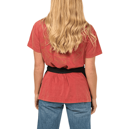The back view of a woman wearing a red t-shirt and jeans, holding a Guinness Kitchen Gift Box.