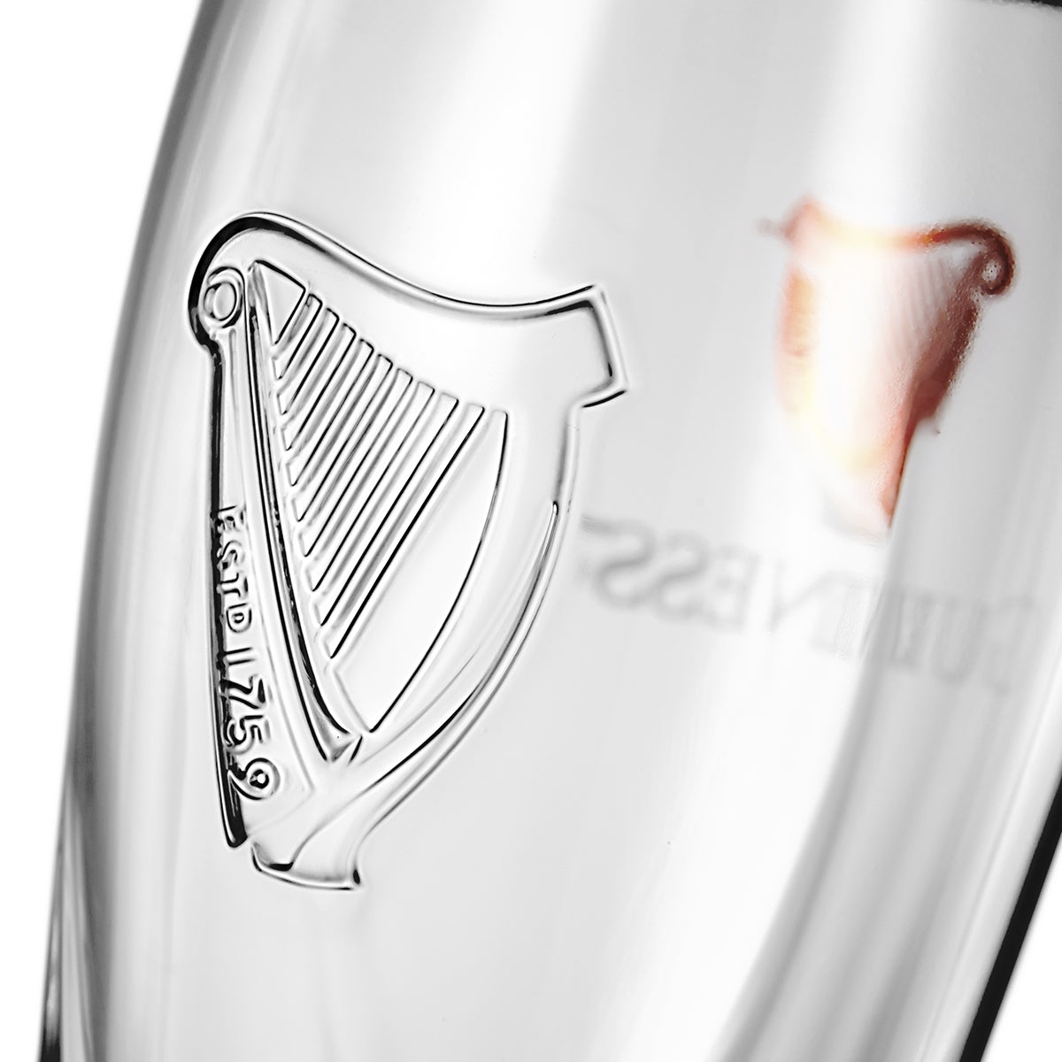 A close up of a Guinness Pint Glass 4 Pack with an embossed harp on it.