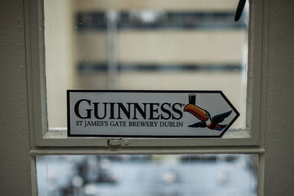Wall art featuring a St James Gate Road Sign with the Guinness brand in a window.