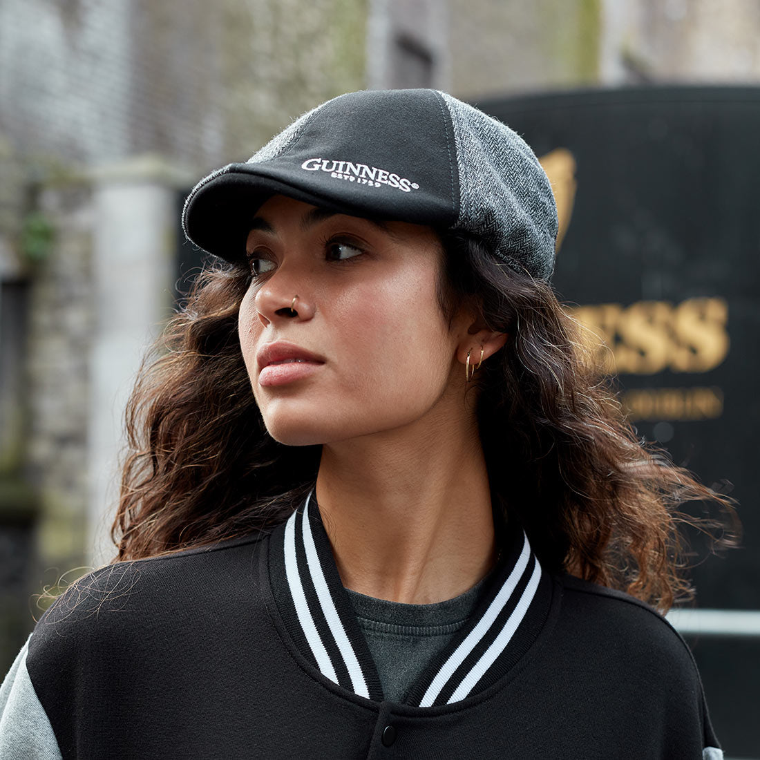 A young woman donning an embroidered Guinness Paneled Ivy Cap.