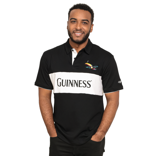 A man wearing a Guinness Black and White Toucan Short Sleeve Rugby polo shirt.