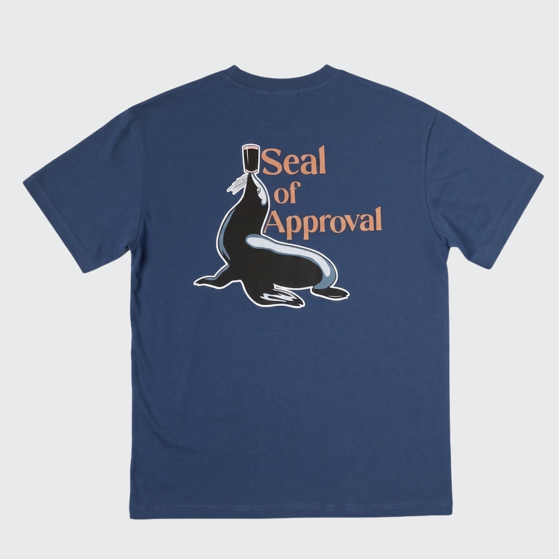 Introducing the Guinness Gilroy Seal Tee – Blue from Guinness Webstore US. This limited edition navy blue T-shirt showcases a playful graphic of a seal balancing a cup, along with the text “Seal of Approval” on the back—drawing inspiration from the iconic Gilroy collection. Perfect for fans who appreciate classic design with a fun twist.