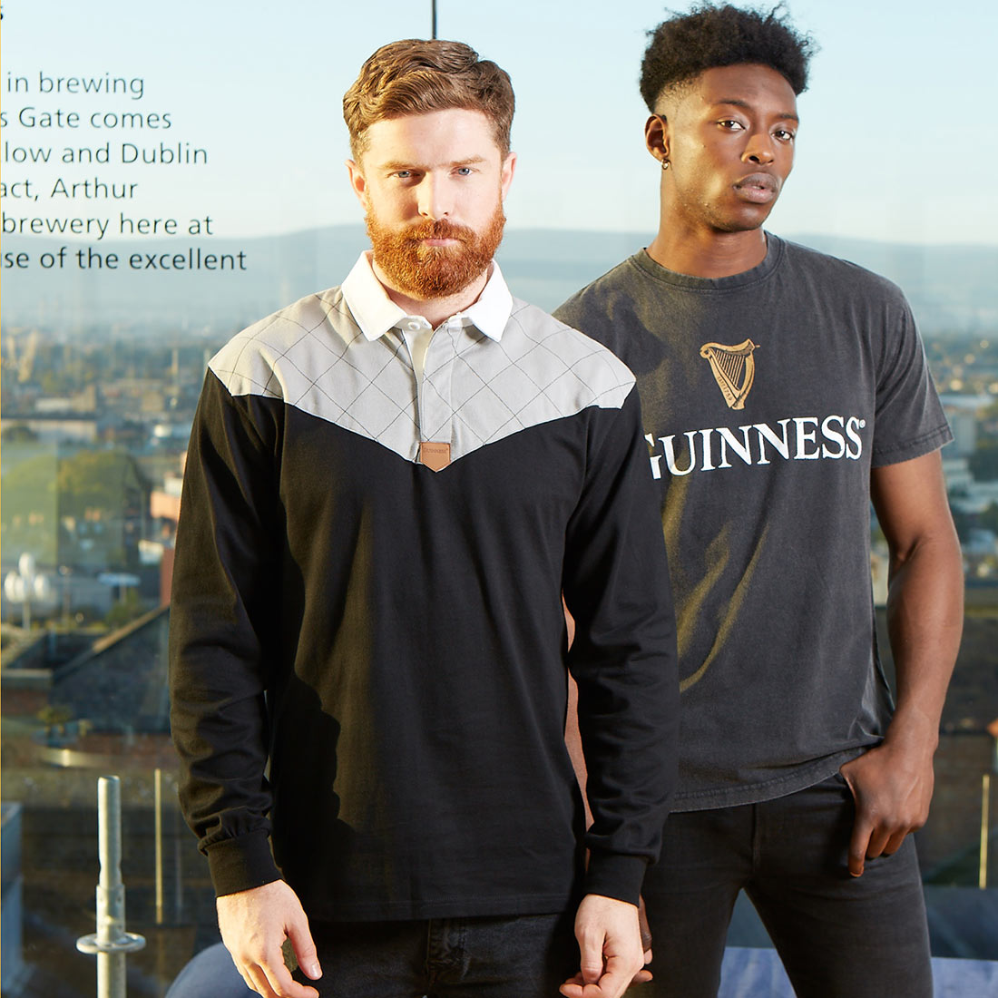 Two men standing next to each other wearing Guinness Guinness Heritage Charcoal Grey & Black Long-Sleeve Rugby t-shirts made of cotton fabric.