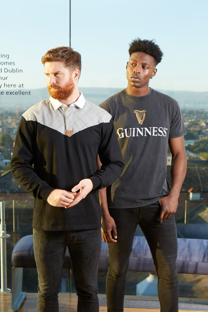 Guinness® Distressed Trademark Label T-Shirt featuring two men in front of a city, proudly showcasing the iconic Guinness label.