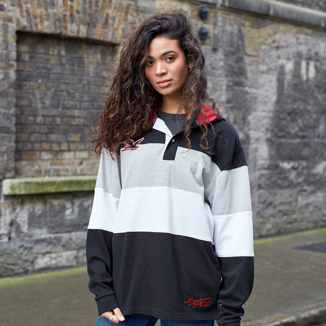 A woman wearing a Guinness Black & Red Toucan Hooded Rugby jersey.