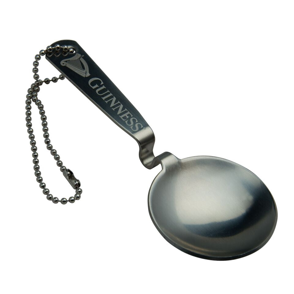 A Guinness stainless steel spoon with a chain attached to it.