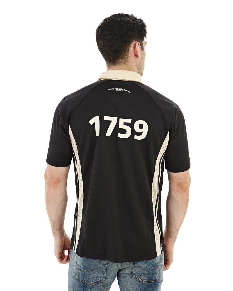 The back of a man wearing a black and white moisture-wicking PERFORMANCE RUGBY JERSEY with Guinness branding.