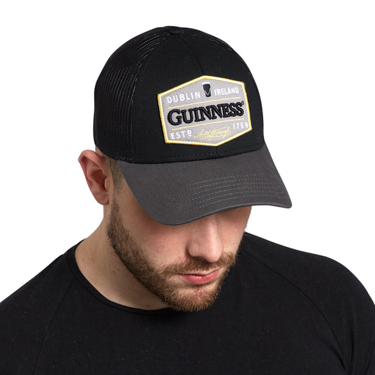 A man wearing a Guinness Trucker Premium Grey with Embroidered Patch Cap.