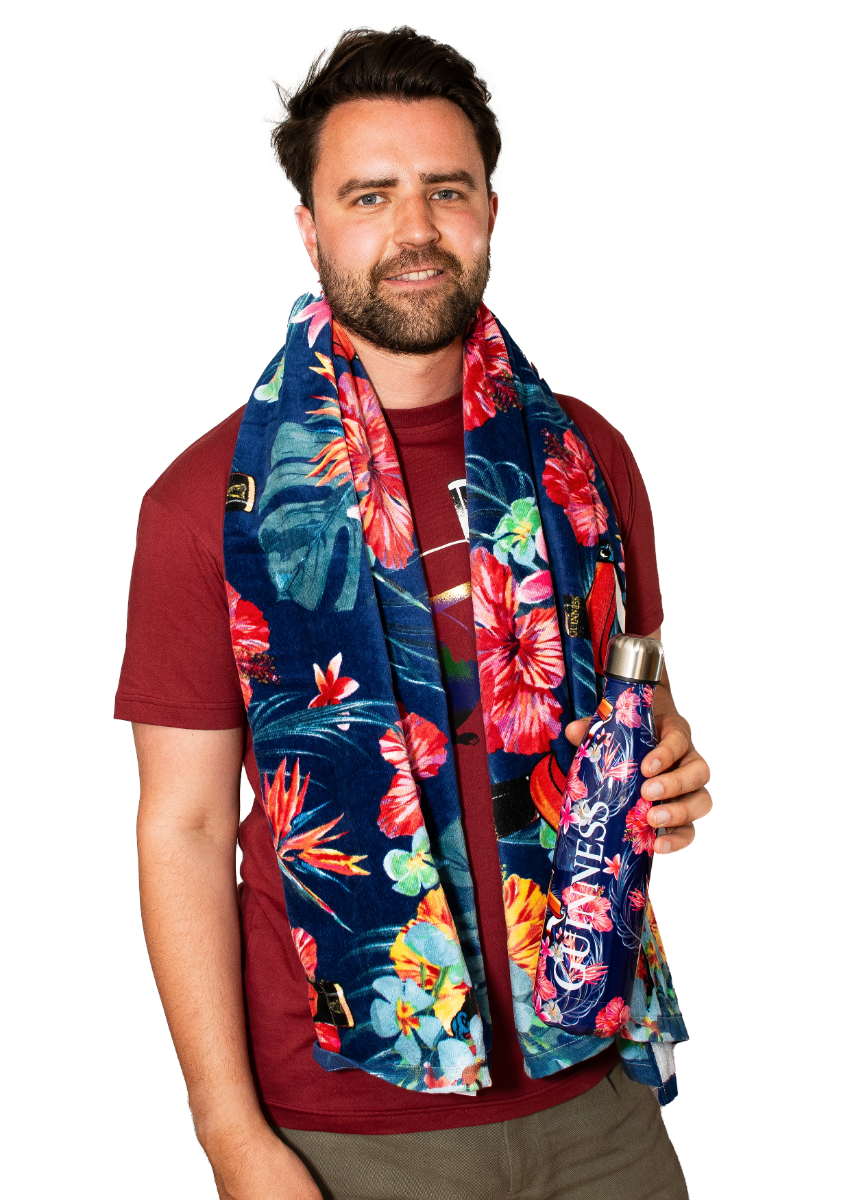 A man wearing a Guinness Toucan Hawaiian print scarf holding a Guinness reusable water bottle.