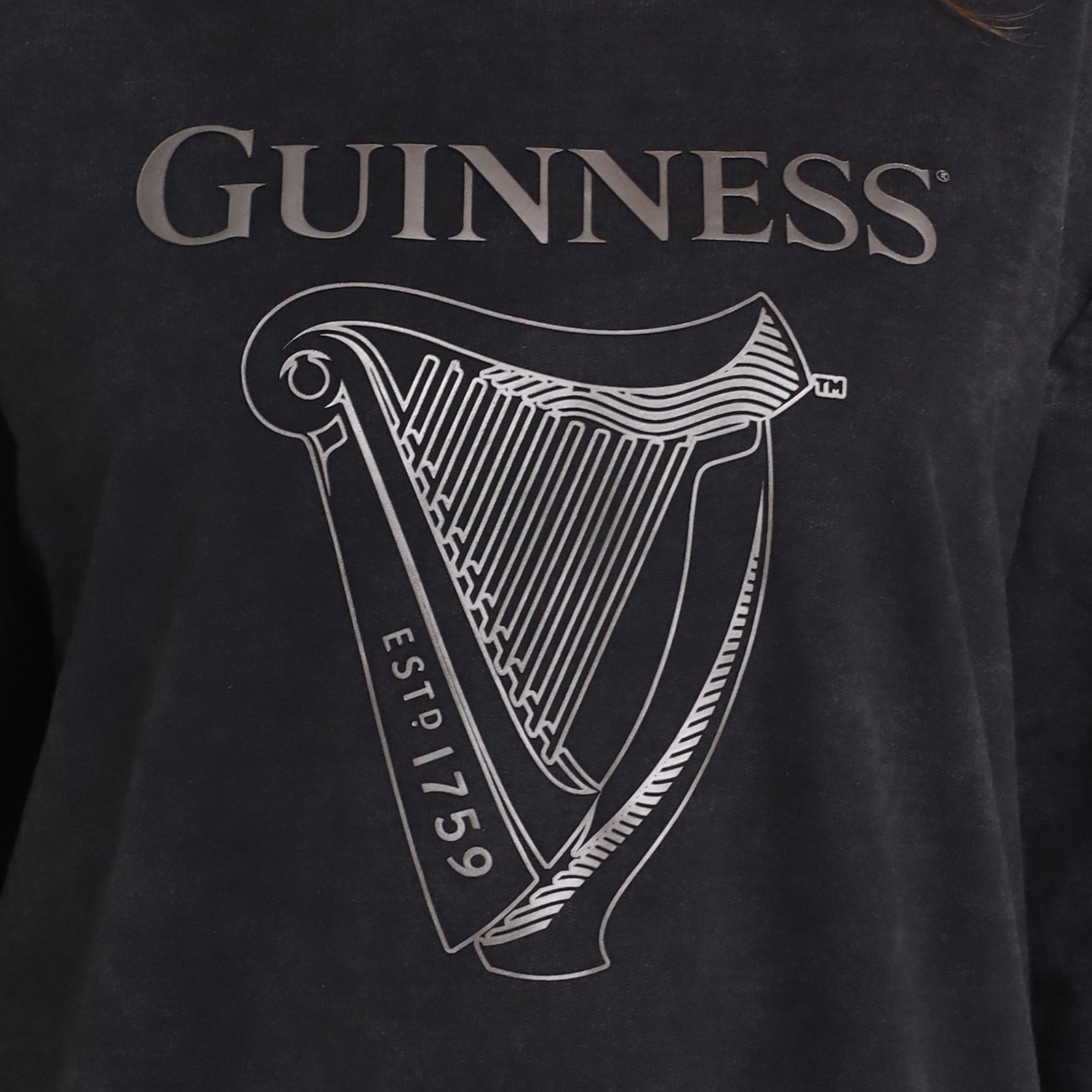 Close-up of the Guinness Embossed Print Trademark Sweater from Guinness Webstore US, crafted from soft BCI cotton fleece with an embossed logo, harp graphic, and "ESTD 1759" for vintage style.