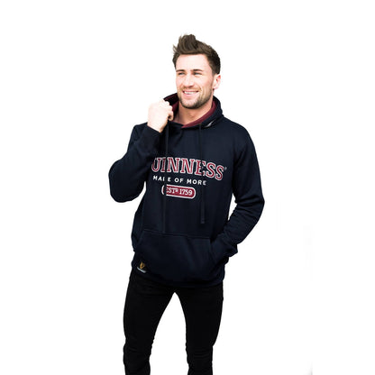 A young man wearing a Guinness Signature Navy Hooded Sweatshirt.