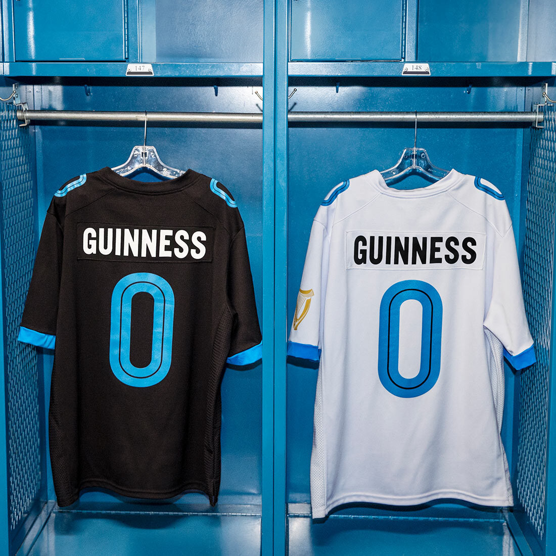 Two Guinness Webstore US white football jerseys hanging in a locker.