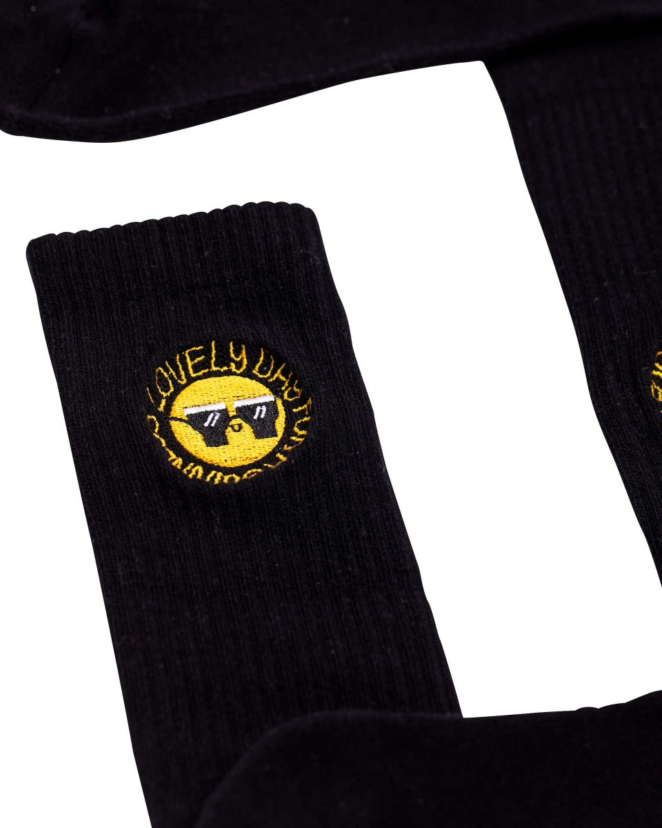 A stylish pair of comfortable FATTI BURKE "LOVELY DAY FOR A GUINNESS" black socks with a yellow Guinness logo on them.