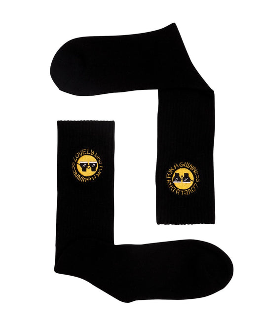 A pair of stylish FATTI BURKE "LOVELY DAY FOR A GUINNESS" black socks with a smiley face on them.