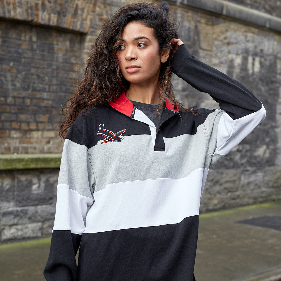 A woman sporting a Guinness Black & Red Toucan Hooded Rugby jersey.