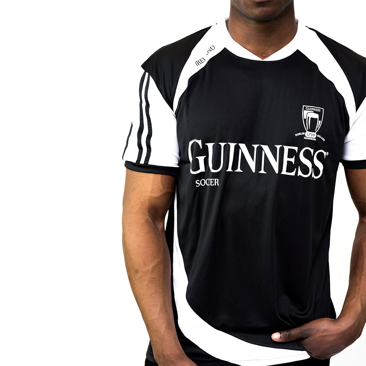 Someone is wearing the Guinness Black & White Soccer Jersey from the Guinness Webstore US, featuring "Guinness" and its iconic logo, echoing the classic 1759 jersey design.