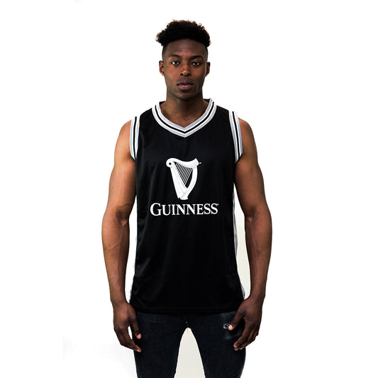 A person wears the Guinness Black & Grey Basketball Jersey from Guinness Webstore US, showcasing the iconic Guinness harp logo and "1759" against a plain white background.