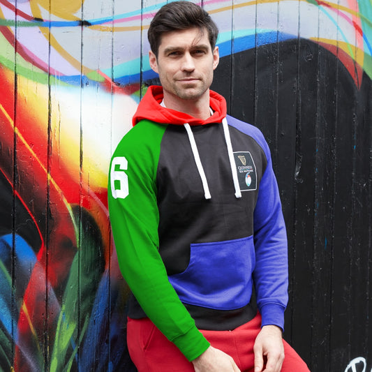 Man in a Guinness Six Nations Color Block Hoodie standing against a vibrant graffiti wall.