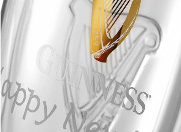 Close-up of a Glassware Personalization item from Guinness Webstore US, with the Guinness logo, golden harp emblem, and engraved text "Happy New" partially visible.